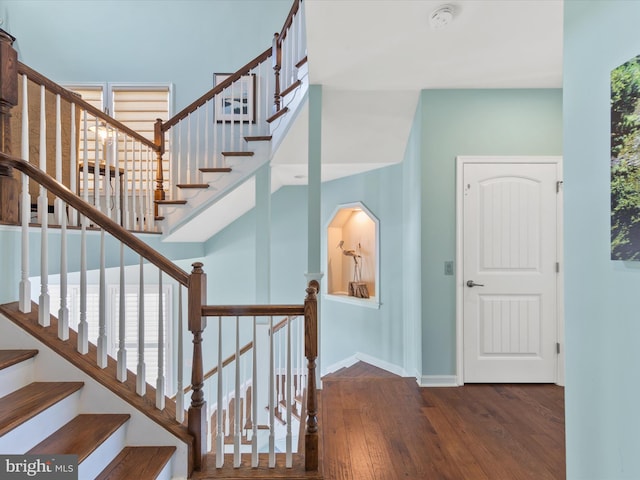 stairs with hardwood / wood-style flooring and a healthy amount of sunlight