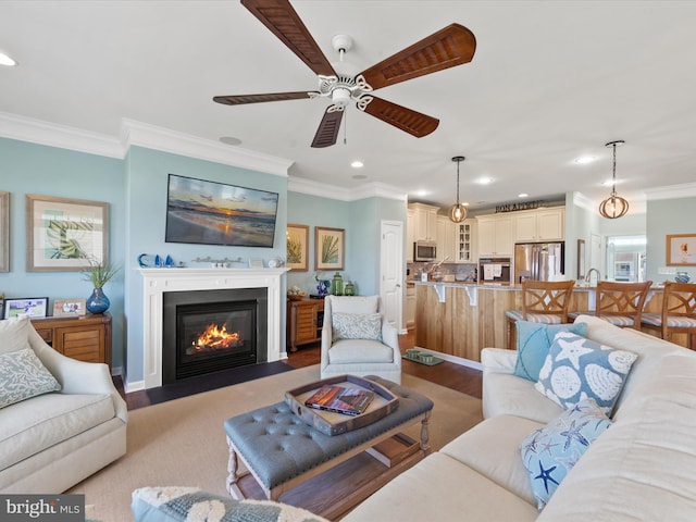 living room with crown molding, ceiling fan, and hardwood / wood-style flooring