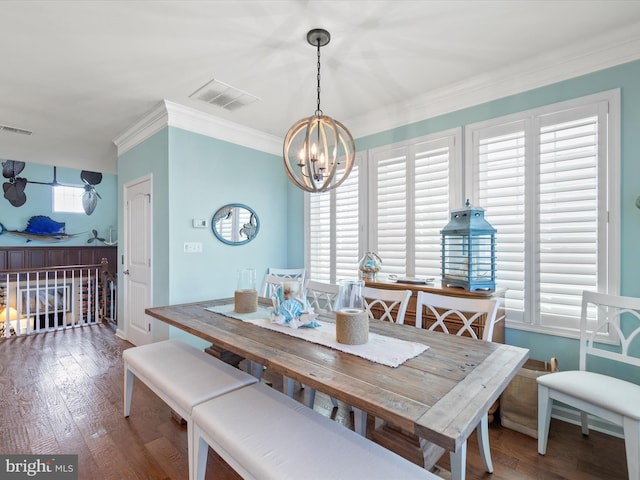 dining room with crown molding, hardwood / wood-style floors, and a notable chandelier