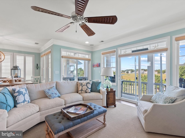 living room featuring crown molding, ceiling fan, and light carpet