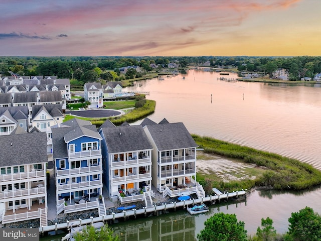 aerial view at dusk featuring a water view