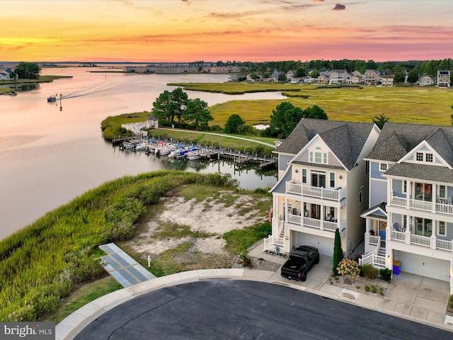 aerial view at dusk featuring a water view