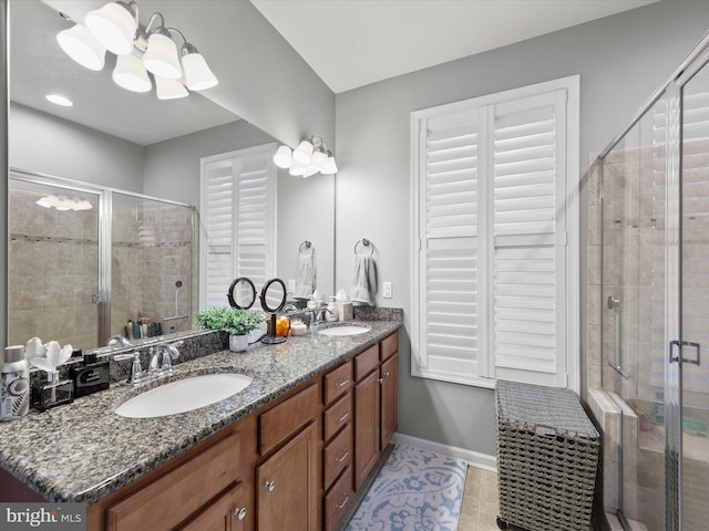 bathroom featuring vanity, an enclosed shower, an inviting chandelier, and tile patterned flooring