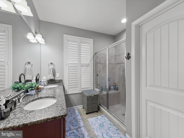 bathroom featuring vanity, an enclosed shower, tile patterned floors, and a skylight