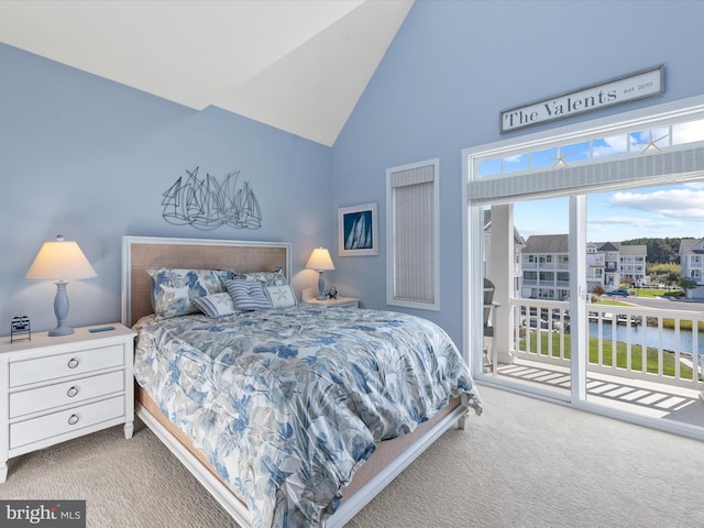 carpeted bedroom with multiple windows, high vaulted ceiling, a water view, and access to exterior