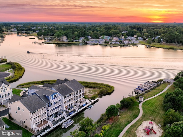 aerial view at dusk featuring a water view