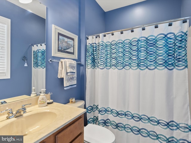 bathroom with vanity, toilet, and walk in shower