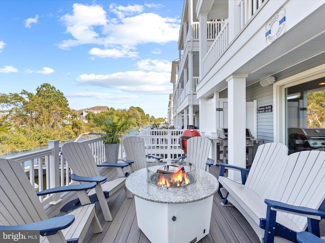 deck featuring a grill and an outdoor fire pit