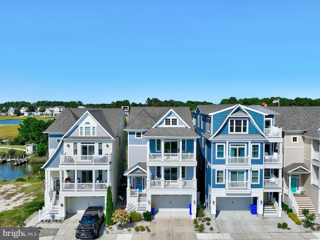 view of front of home featuring a water view, a garage, and a balcony