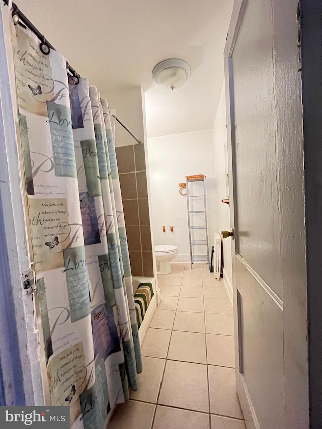 bathroom with a shower with shower curtain, tile patterned flooring, and toilet