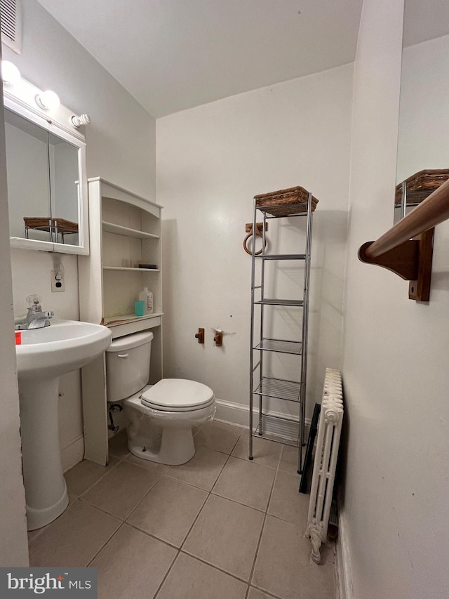 bathroom featuring radiator, tile patterned flooring, and toilet