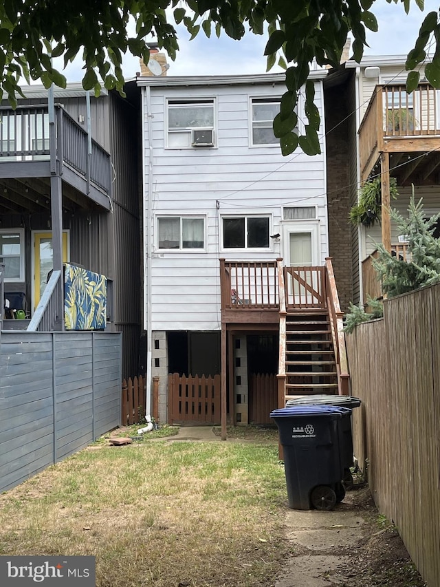 rear view of house with a yard, fence, stairs, and a wooden deck