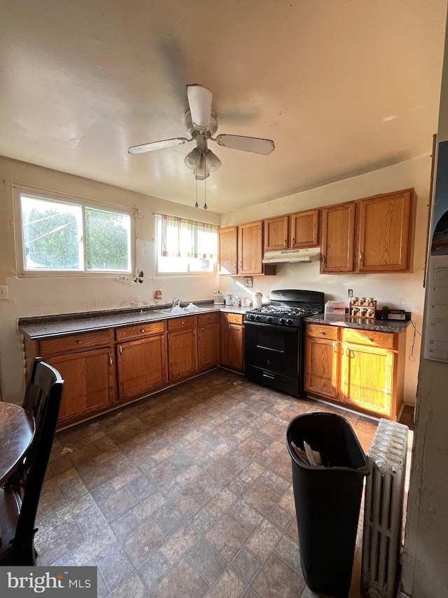 kitchen with black gas range, radiator heating unit, and ceiling fan