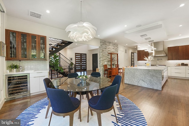 dining space with visible vents, wood finished floors, recessed lighting, stairway, and wine cooler