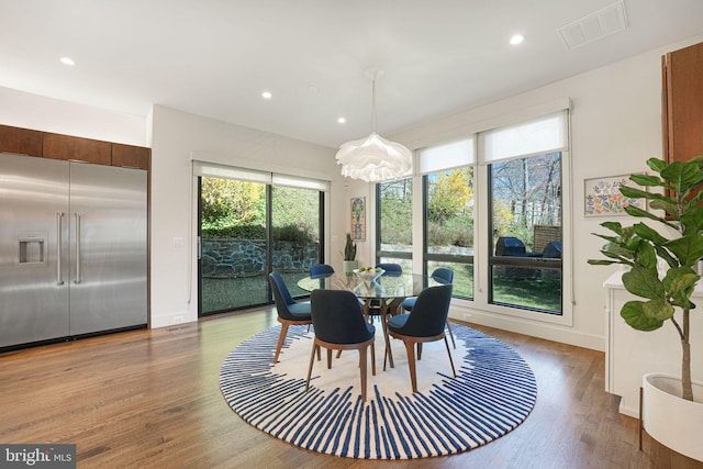 dining space with light wood-style flooring, recessed lighting, visible vents, and baseboards