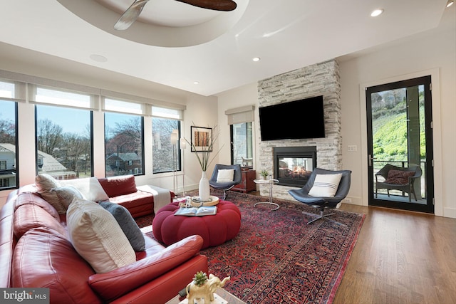 living room with a fireplace, hardwood / wood-style floors, a wealth of natural light, and ceiling fan