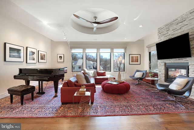 living area with a fireplace, baseboards, and wood finished floors