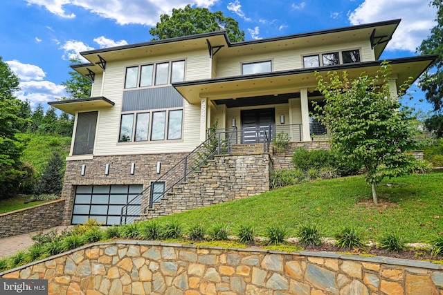 view of front of property with stairway, driveway, a porch, an attached garage, and stone siding