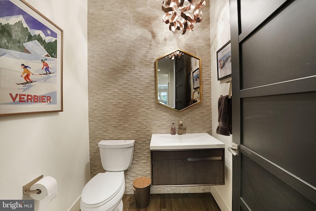 half bath featuring toilet, wood finished floors, and vanity