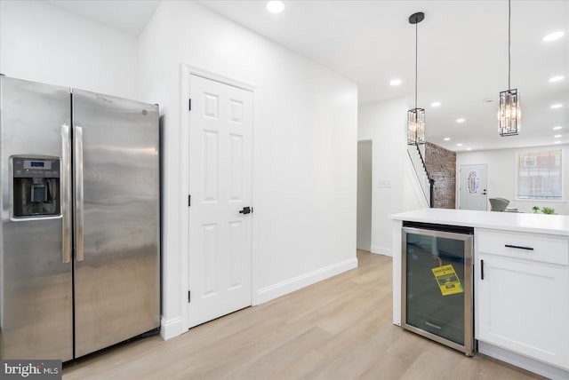 kitchen featuring stainless steel fridge, light hardwood / wood-style flooring, decorative light fixtures, wine cooler, and white cabinets