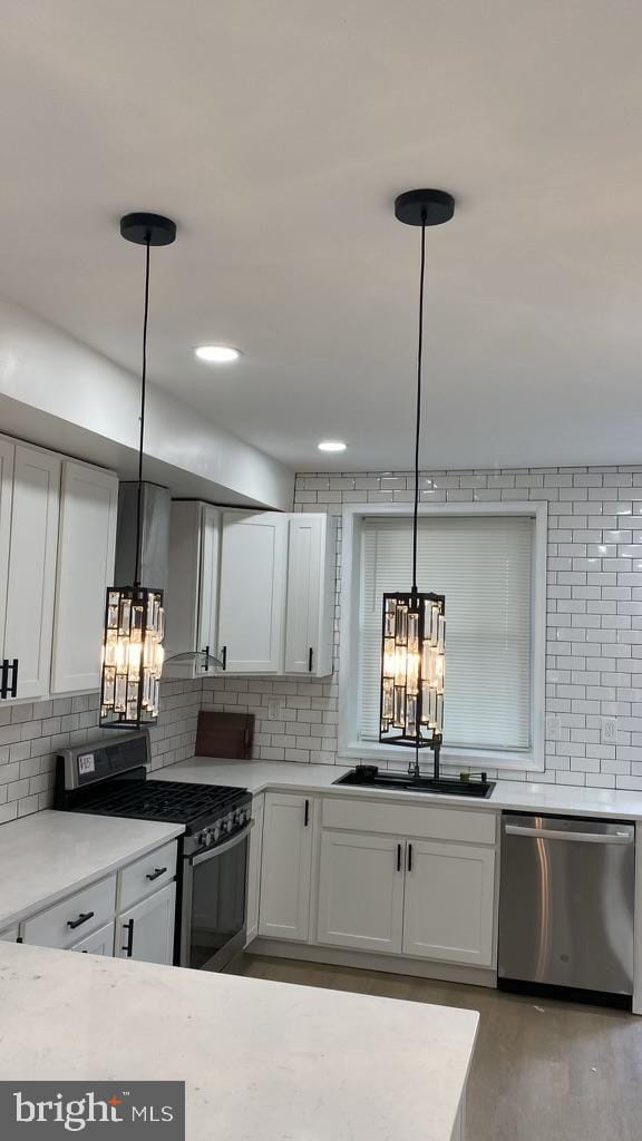 kitchen with hanging light fixtures, sink, appliances with stainless steel finishes, and a notable chandelier