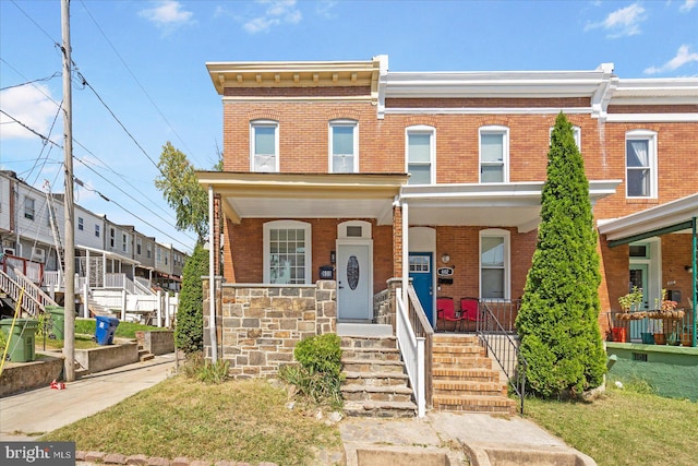 multi unit property with a porch and a front yard