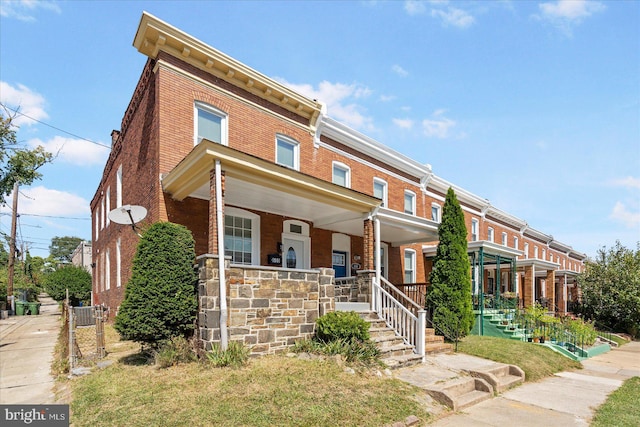 townhome / multi-family property featuring covered porch