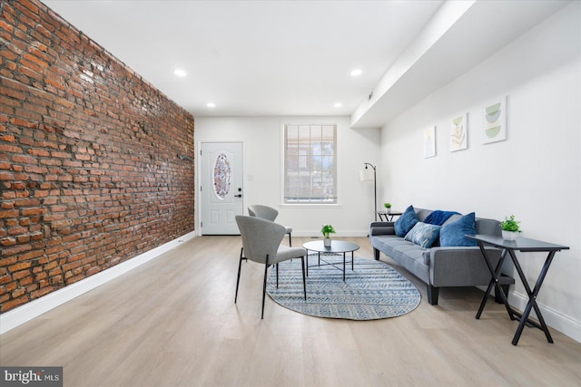 living room featuring light wood-type flooring and brick wall