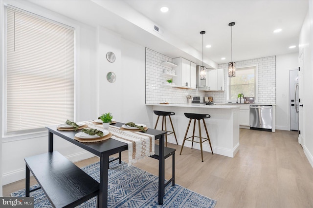 dining area featuring light wood-type flooring and sink