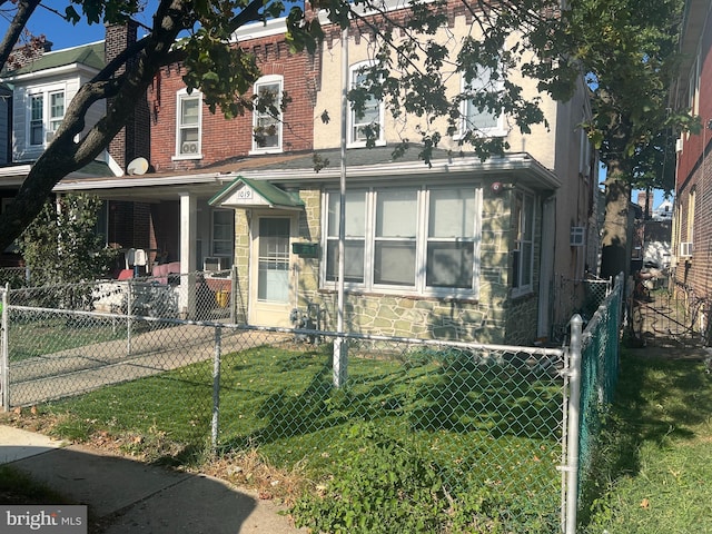 view of front of home featuring a fenced front yard, stone siding, and a front yard