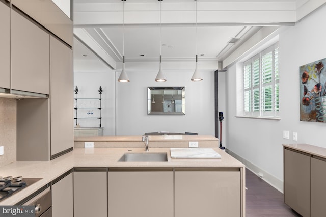 kitchen featuring pendant lighting, dark wood-type flooring, stainless steel stovetop, sink, and kitchen peninsula