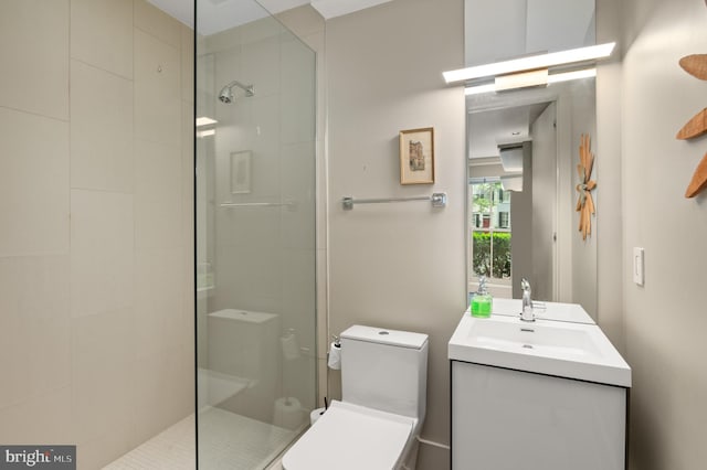 bathroom with vanity, toilet, and a tile shower