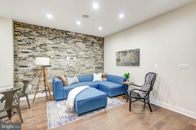 living area with baseboards, wood finished floors, and recessed lighting