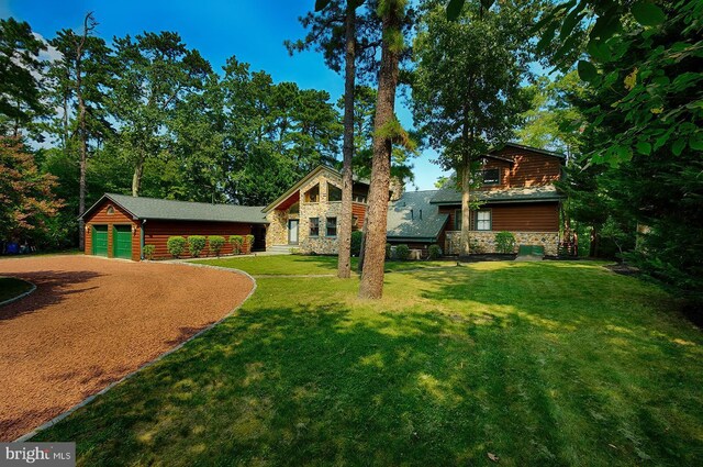 view of front facade with a front lawn, a garage, and an outdoor structure