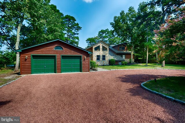 view of front of property featuring an outdoor structure, a garage, and a front yard