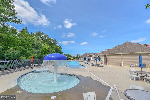 view of swimming pool featuring pool water feature and a patio area