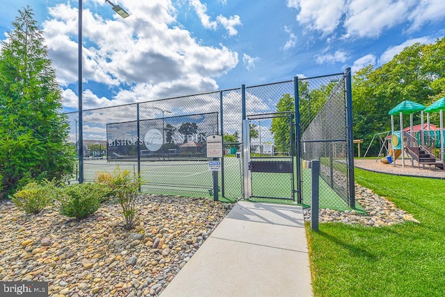 view of tennis court featuring a playground