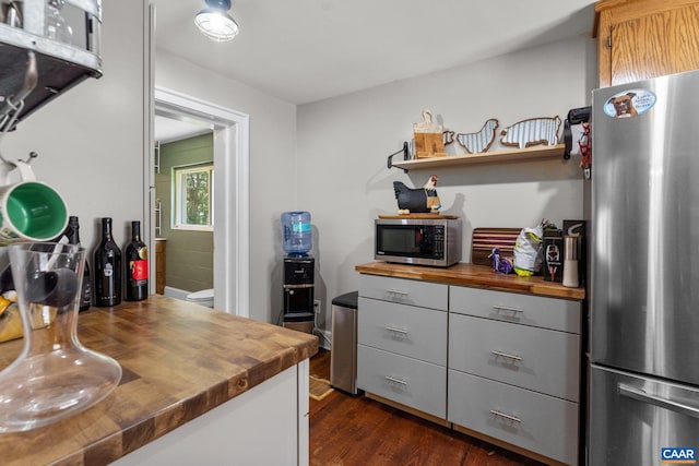 kitchen with gray cabinets, stainless steel appliances, dark hardwood / wood-style flooring, and butcher block counters