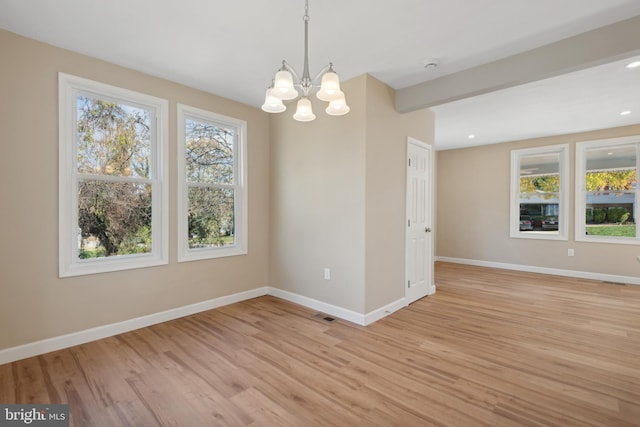 unfurnished room featuring beamed ceiling, an inviting chandelier, and light hardwood / wood-style flooring