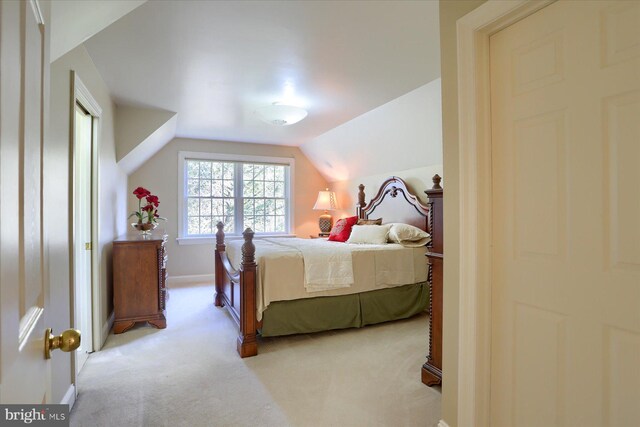 carpeted bedroom with lofted ceiling