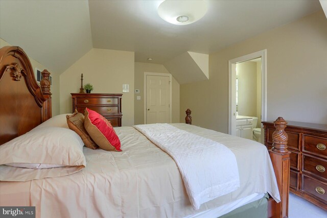 bedroom with lofted ceiling and connected bathroom