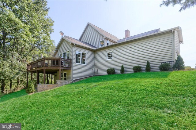 rear view of house with a deck and a lawn