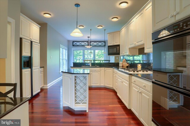 kitchen featuring pendant lighting, dark hardwood / wood-style floors, white cabinets, and black appliances