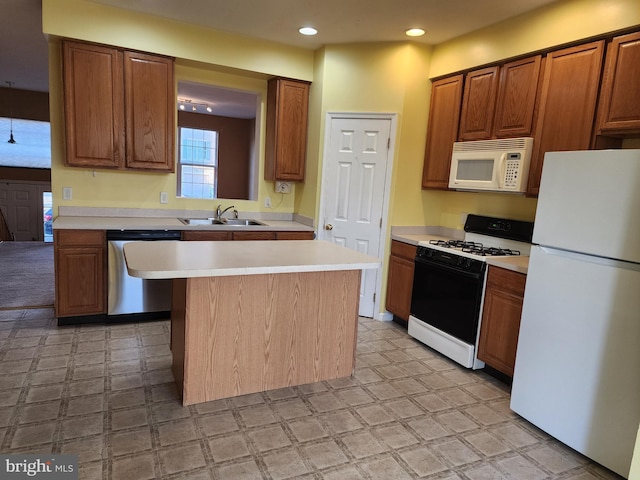 kitchen with white appliances, light floors, and a sink