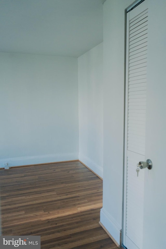 empty room with dark hardwood / wood-style flooring