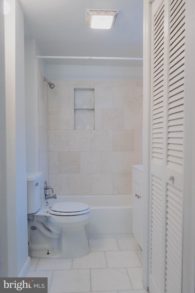 bathroom featuring toilet, tile patterned floors, and tiled shower / bath