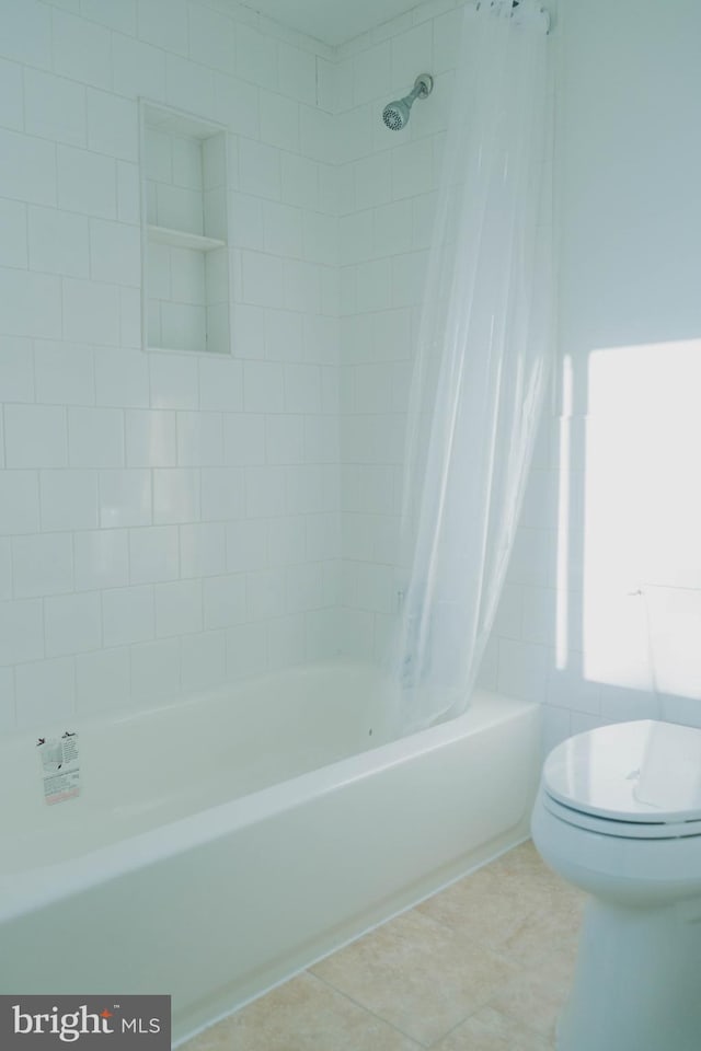 bathroom featuring tile patterned flooring, toilet, and shower / bath combination with curtain