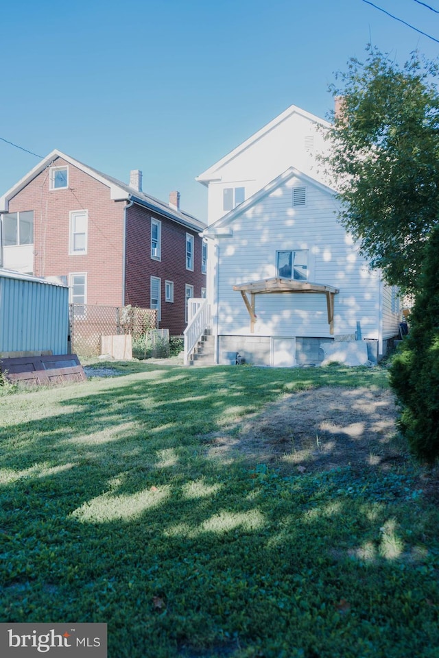 back of property featuring a yard