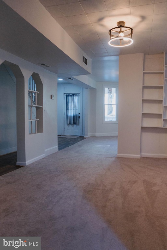 unfurnished living room with carpet and a chandelier