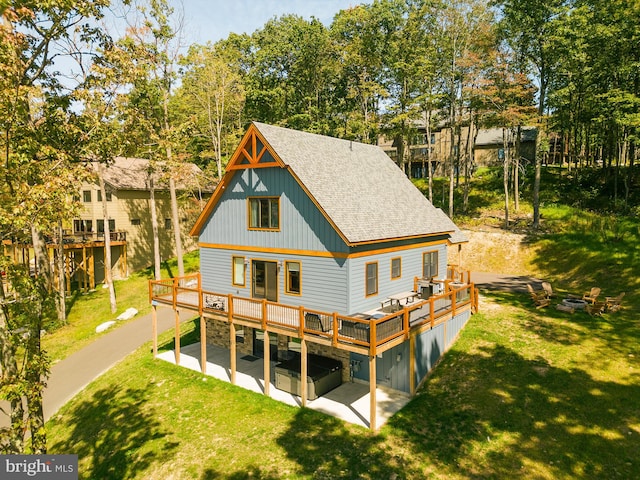 rear view of house with a wooden deck and a lawn